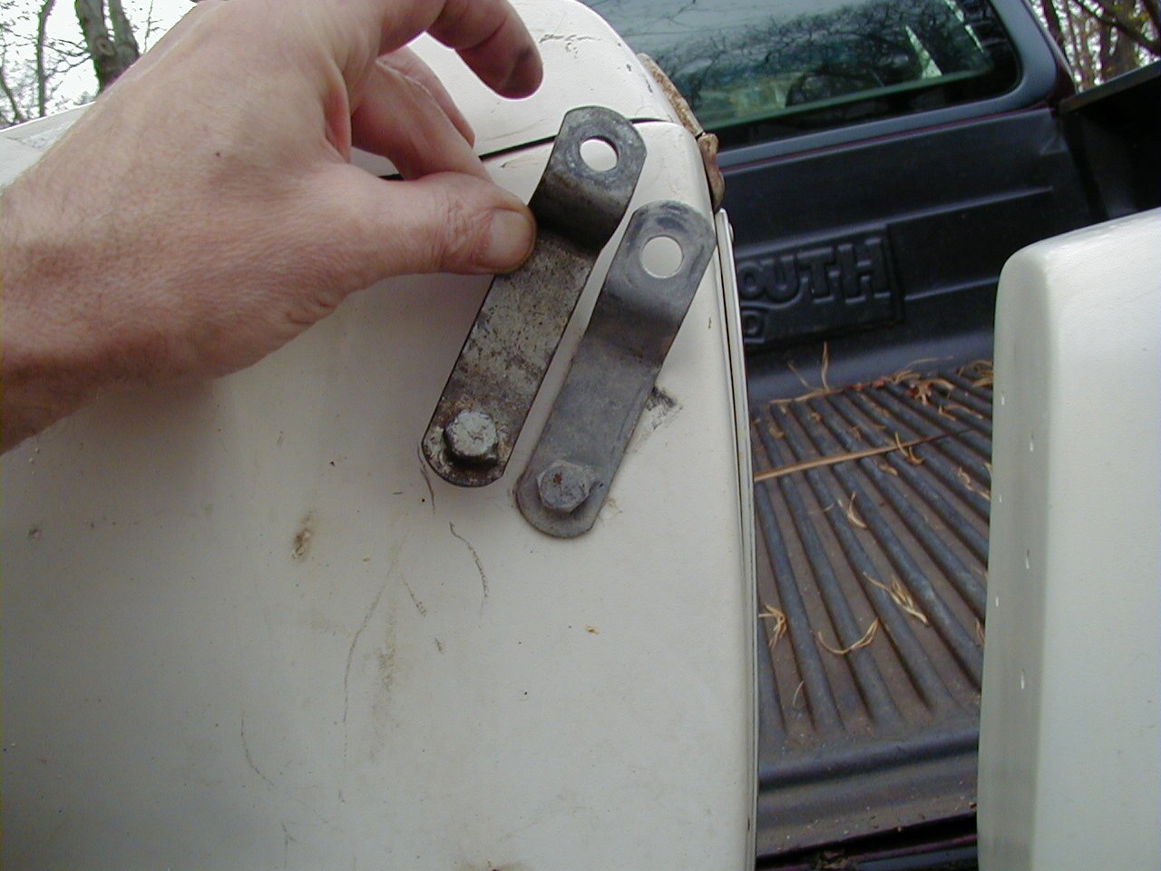 DB saddlebag upper front bracket that attaches to the top shock mount. Loop bracket is being held by Charley; Tonti bracket is secured to the saddlebag.