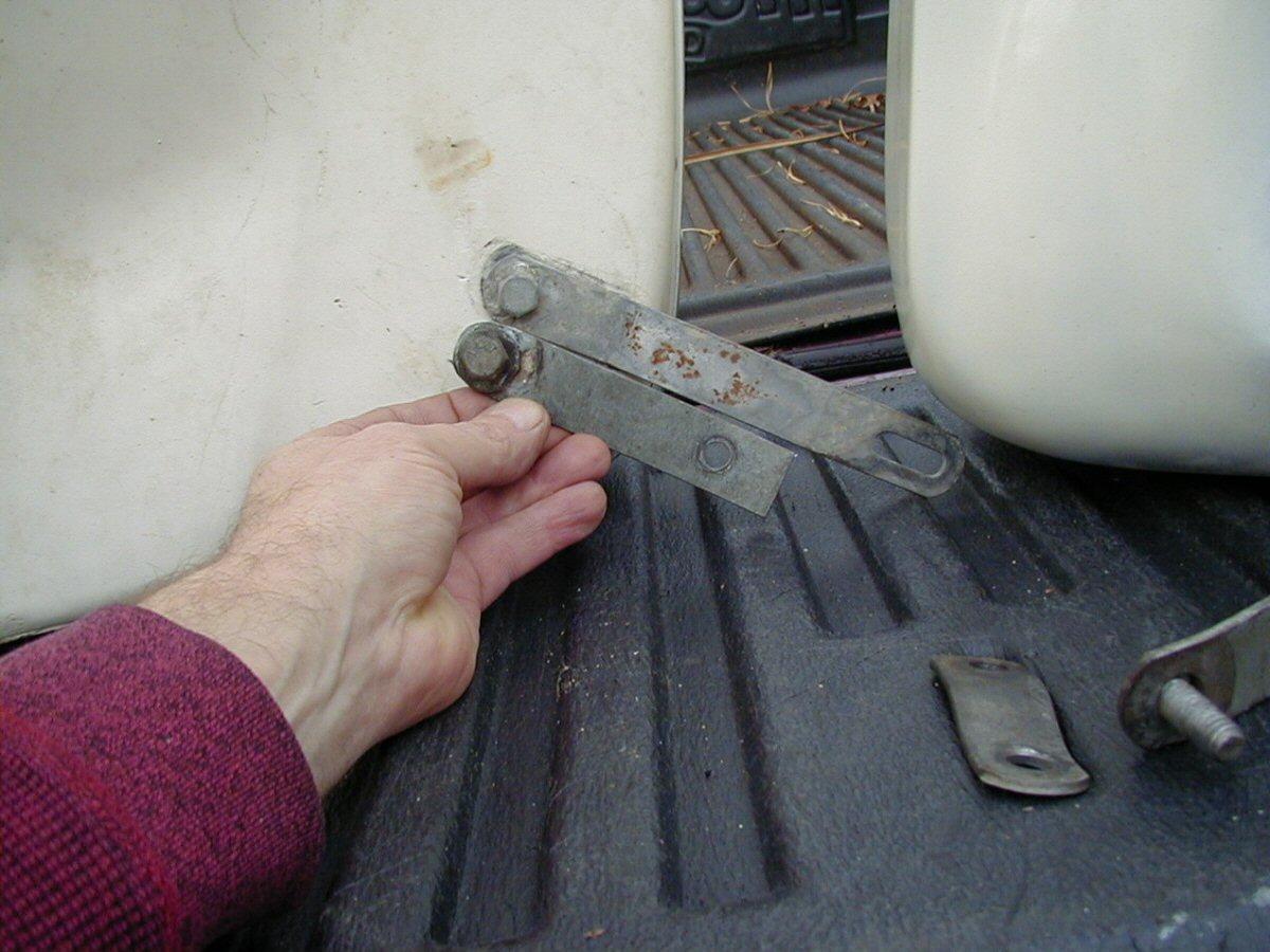 DB saddlebag lower front bracket that attaches to the muffler bracket. Loop bracket is being held by Charley; Tonti bracket is secured to the saddlebag.